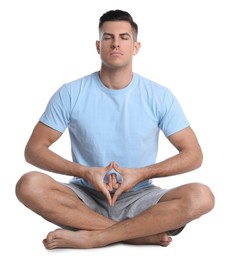 Photo of Handsome man meditating on white background. Harmony and zen