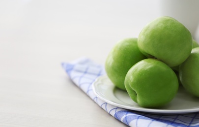 Photo of Plate with ripe green apples on table