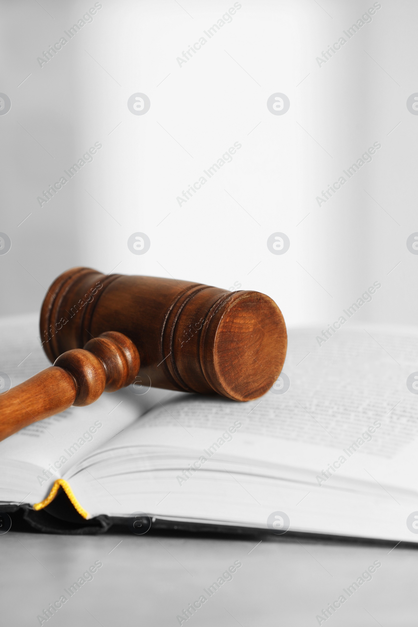 Photo of Law concept. Gavel and book on light table, closeup. Space for text