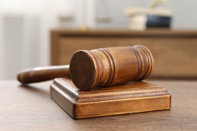 Wooden gavel and sound block on table indoors, closeup