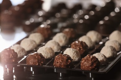 Photo of Many delicious chocolate candies on table. Production line