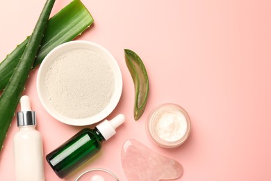 Flat lay composition with cosmetic products and cut aloe leaves on pink background. Space for text