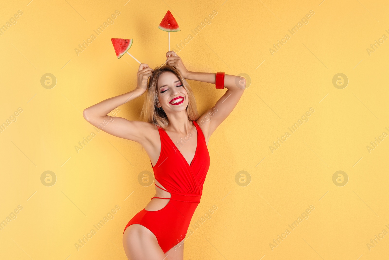 Photo of Pretty young woman with juicy watermelon on color background