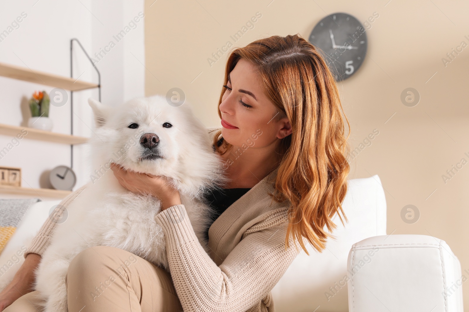 Photo of Beautiful woman with her dog sitting on sofa at home