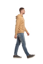 Man in casual outfit walking on white background