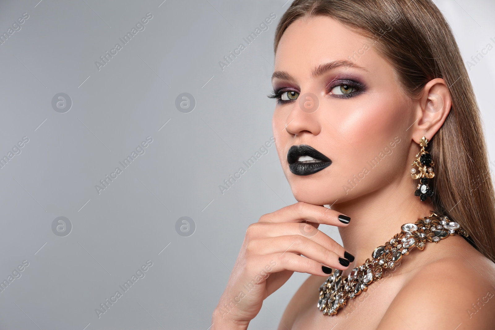 Photo of Beautiful woman with stylish nail polish on grey background, space for text