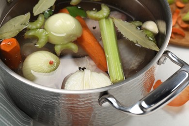 Different ingredients for cooking tasty bouillon in pot on table, closeup