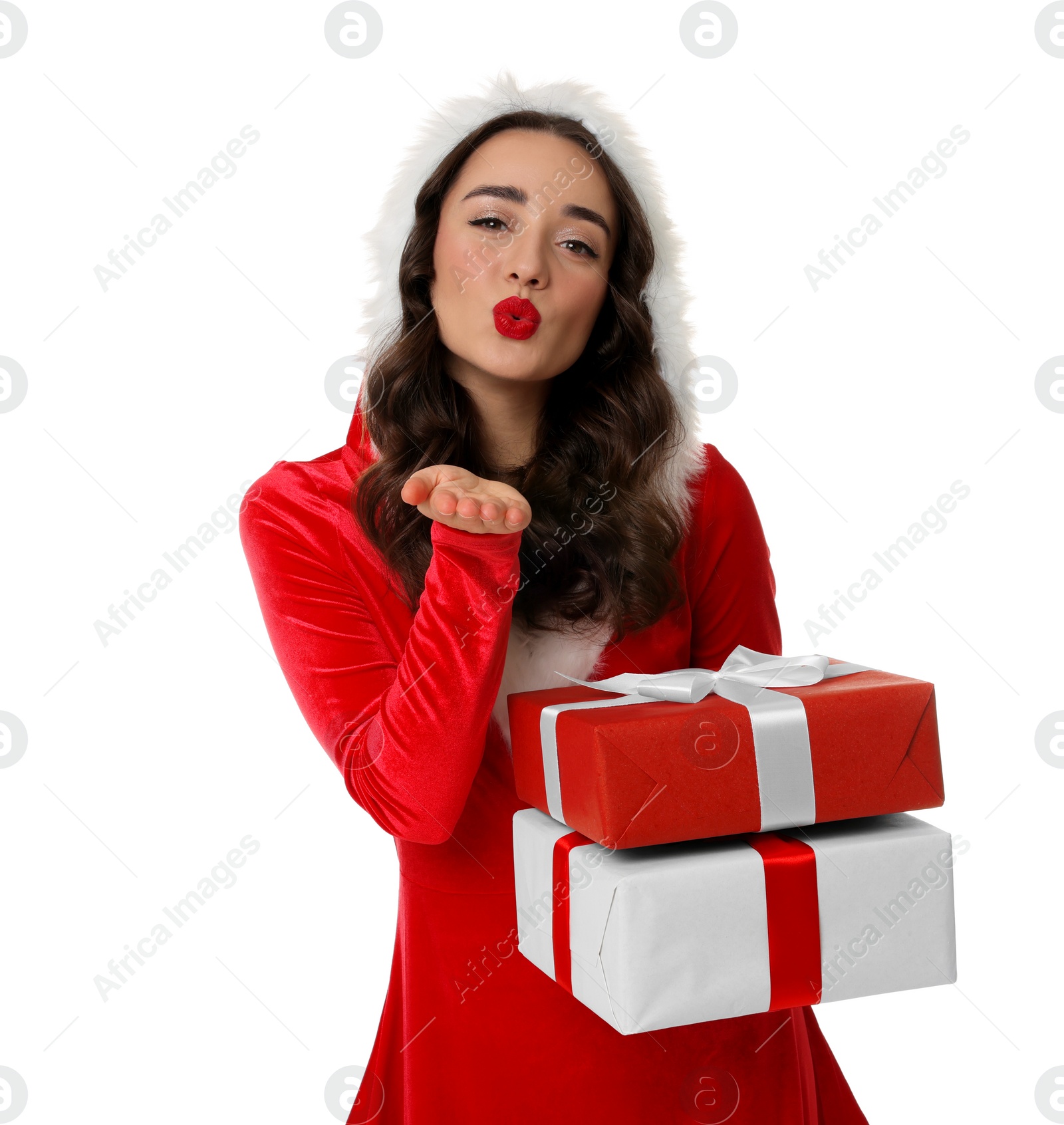 Photo of Beautiful young woman in Christmas red dress with gift boxes blowing kiss on white background