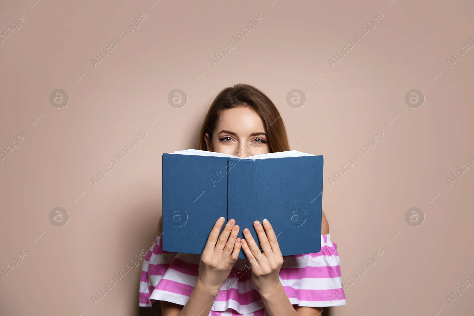 Photo of Young woman with book on color background