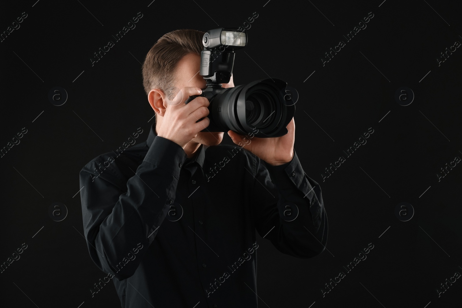 Photo of Professional photographer taking picture on black background