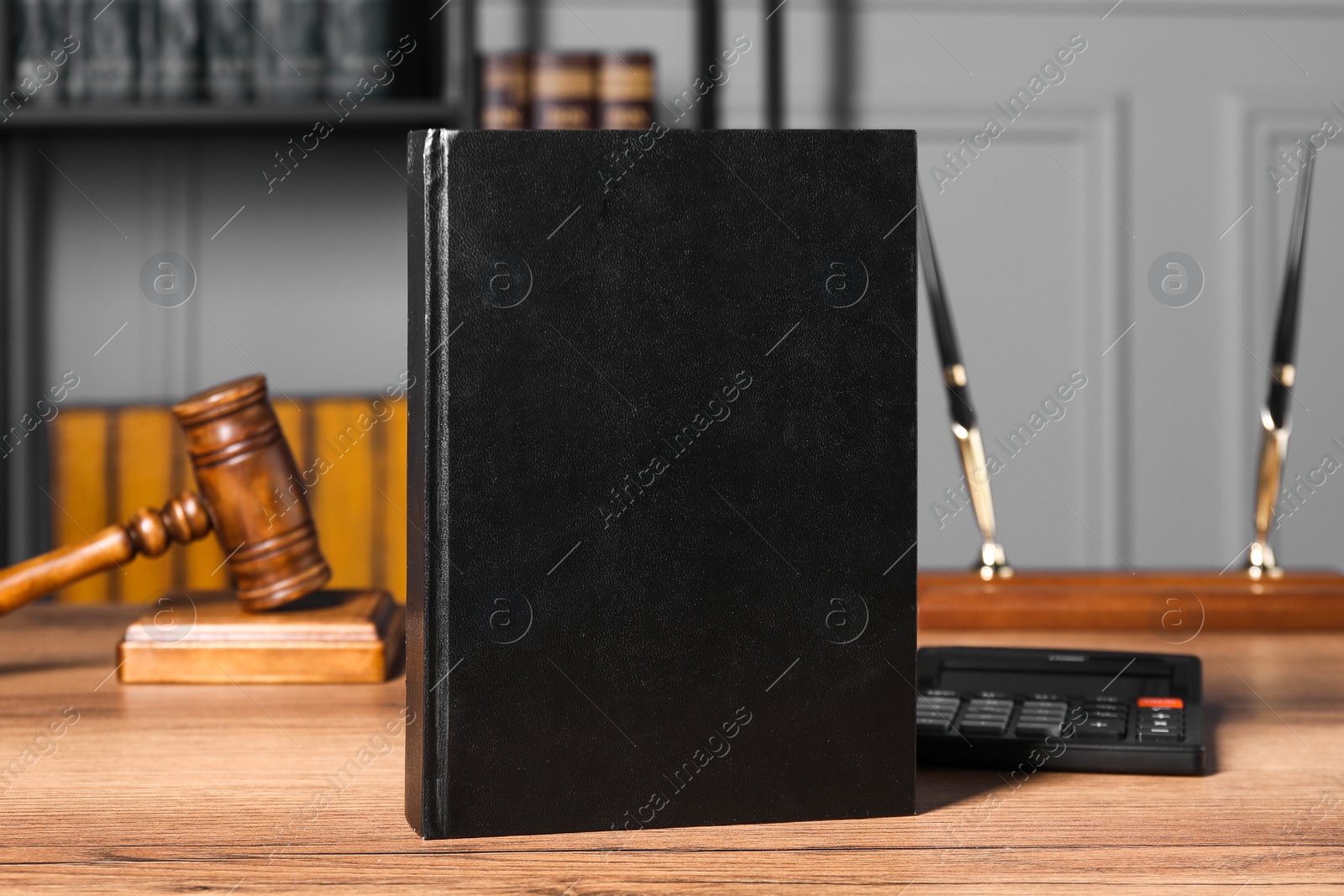 Photo of Tax law. Book, calculator and gavel on wooden table