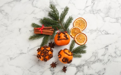 Flat lay composition with pomander balls made of fresh tangerines and cloves on white marble table