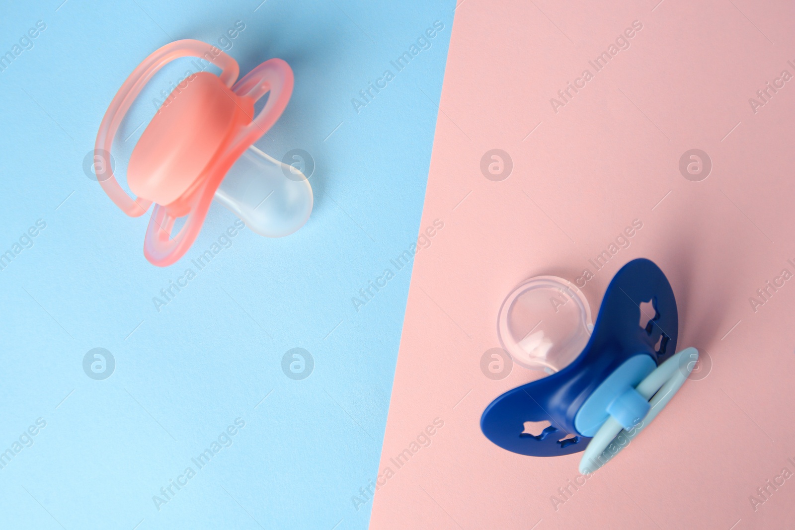 Photo of Baby pacifiers on color background, flat lay