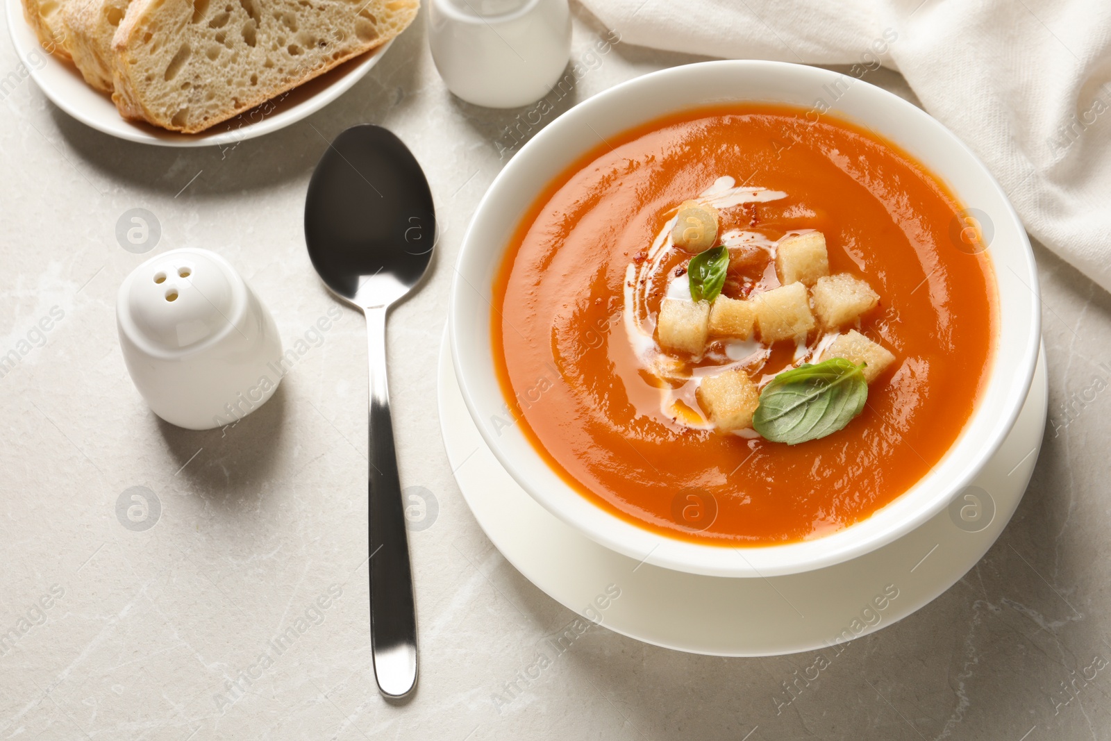 Photo of Bowl of tasty sweet potato soup served on table, above view