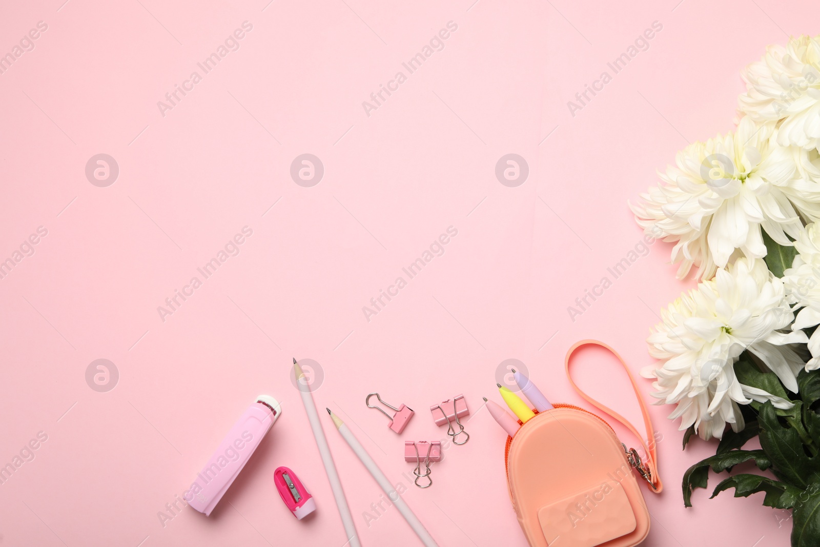 Photo of Flat lay composition with flowers and stationery on pink background, space for text. Teacher's day