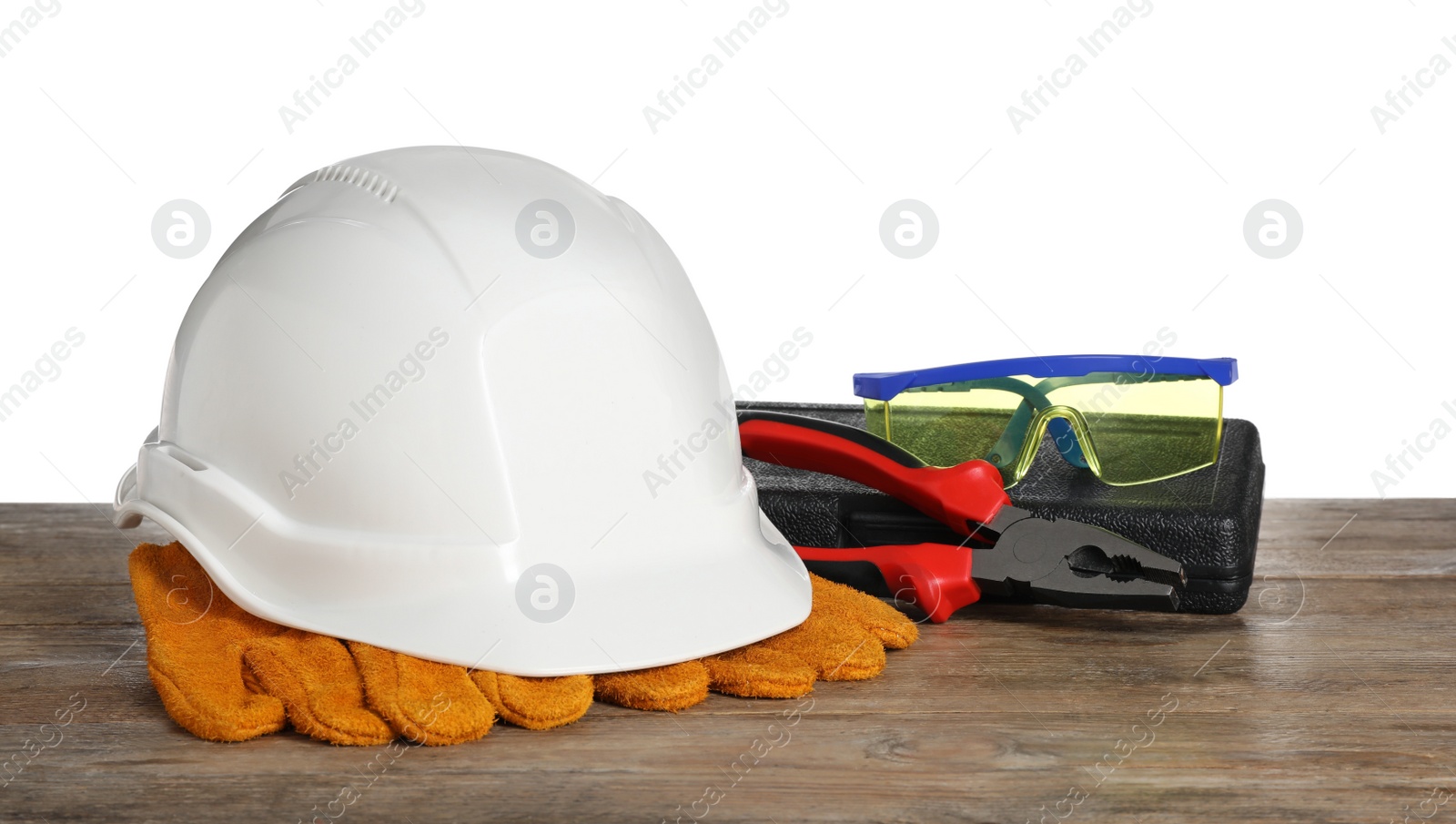 Photo of Personal protective equipment and tool on wooden surface against white background