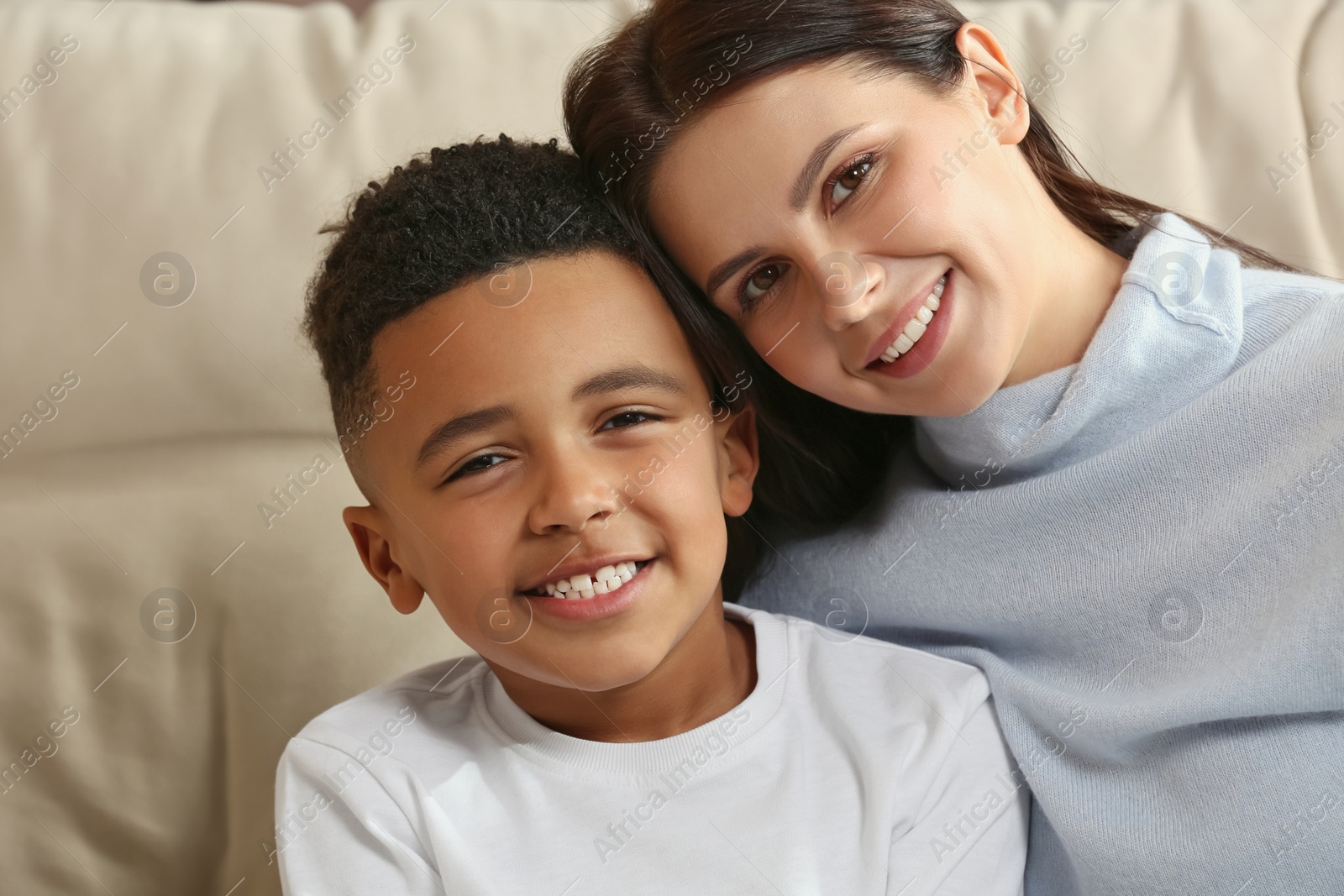 Photo of Mother with her African American son on sofa. International family