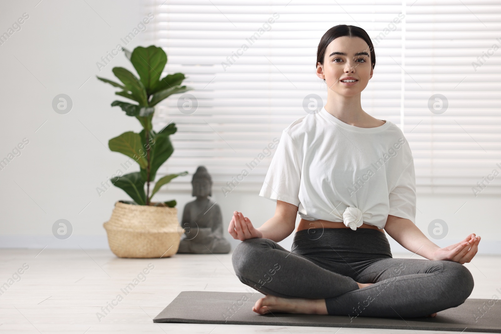 Photo of Beautiful girl meditating on mat in yoga studio