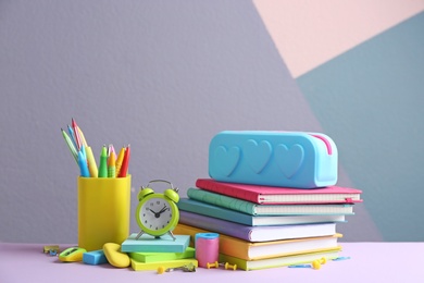 Different school stationery on table against color background