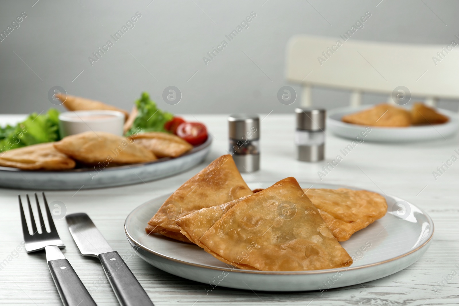 Photo of Fresh delicious crispy samosas served on white  wooden table