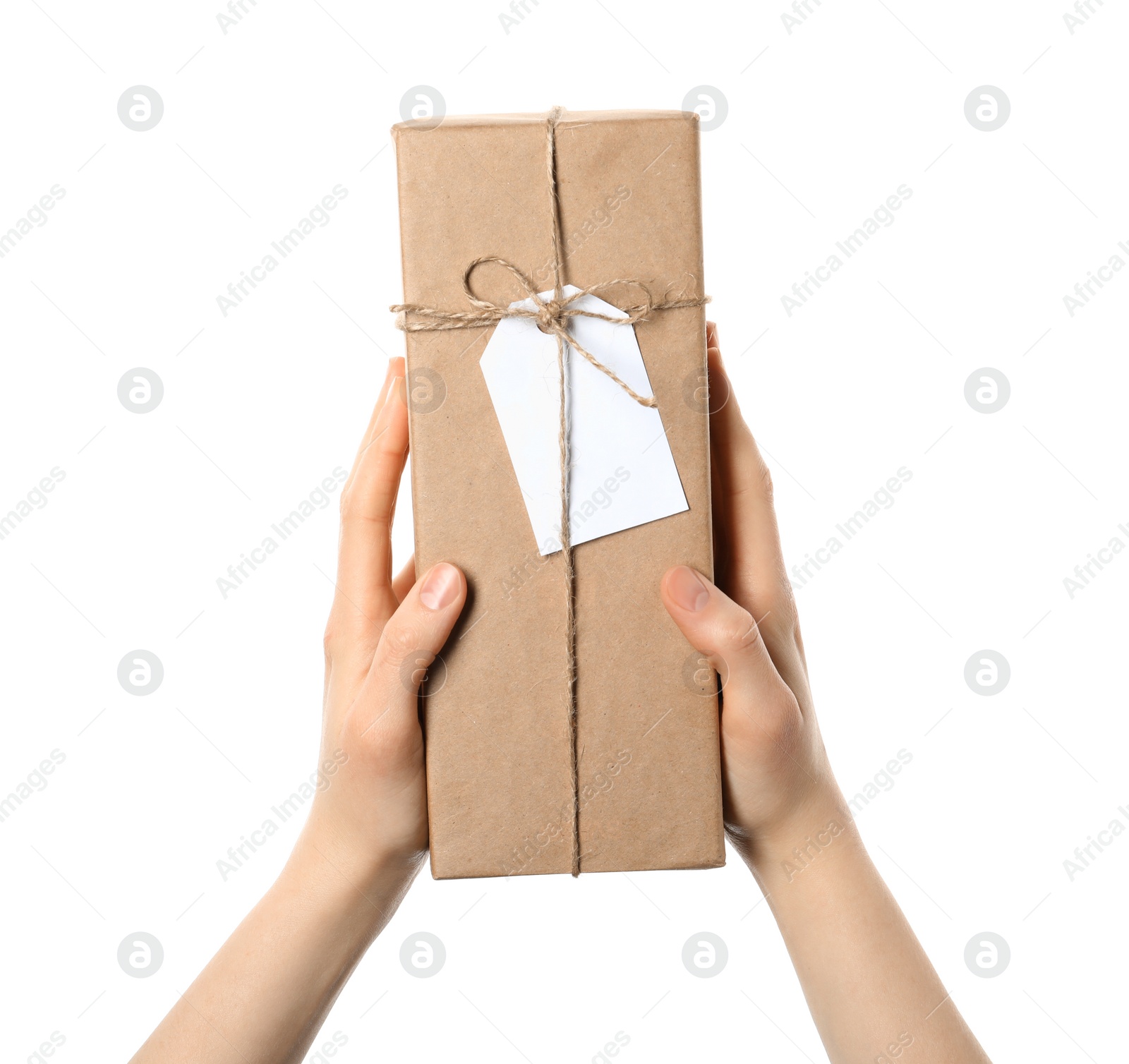 Photo of Woman holding parcel wrapped in kraft paper with tag on white background, closeup