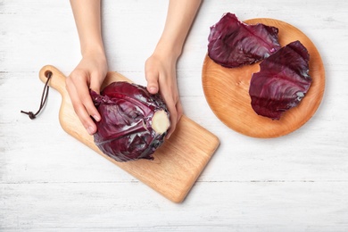 Photo of Woman preparing red cabbage at table, top view