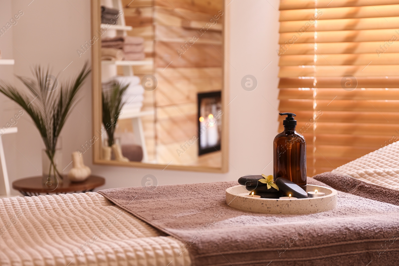 Photo of Beautiful spa accessories on massage table in room