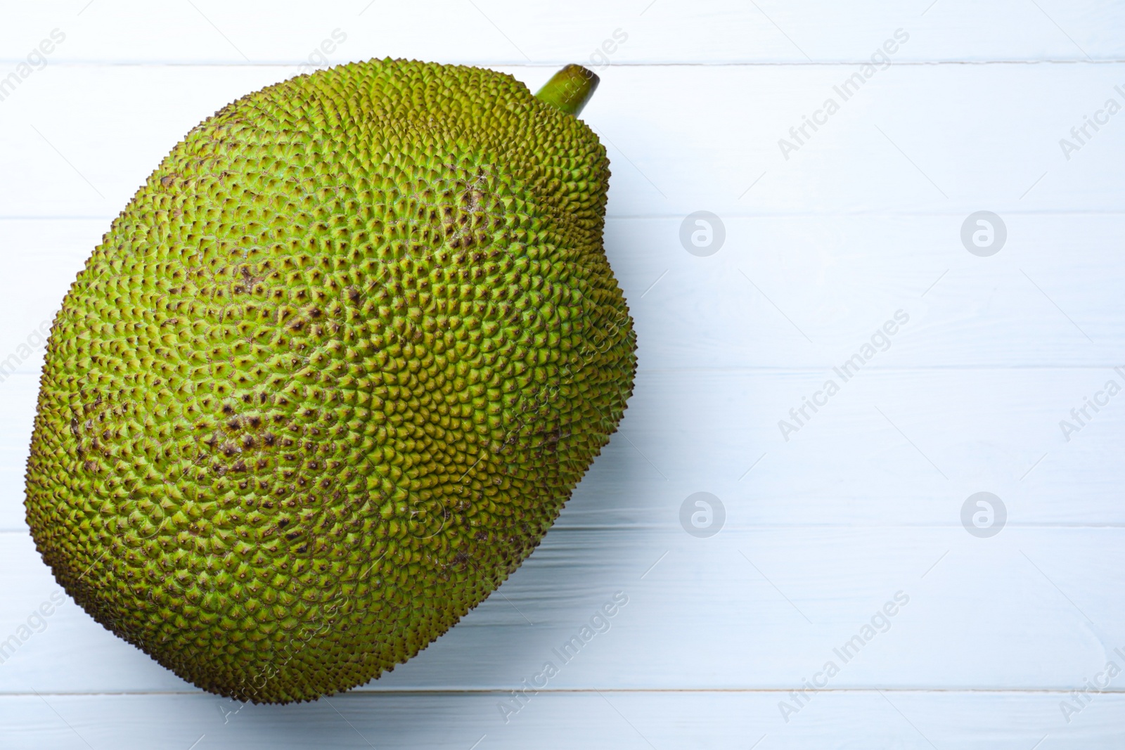 Photo of Delicious fresh exotic jackfruit on white table, top view. Space for text