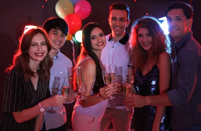 Photo of Young people celebrating birthday in nightclub