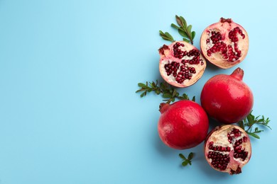 Photo of Flat lay composition with ripe pomegranates on light blue background. Space for text