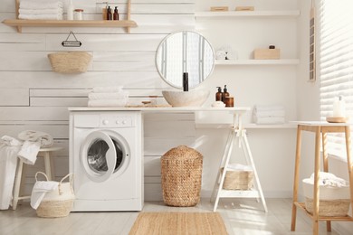 Photo of Stylish bathroom interior with modern washing machine
