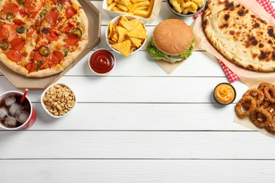 Photo of Pizza, onion rings and other fast food on white wooden table, flat lay with space for text