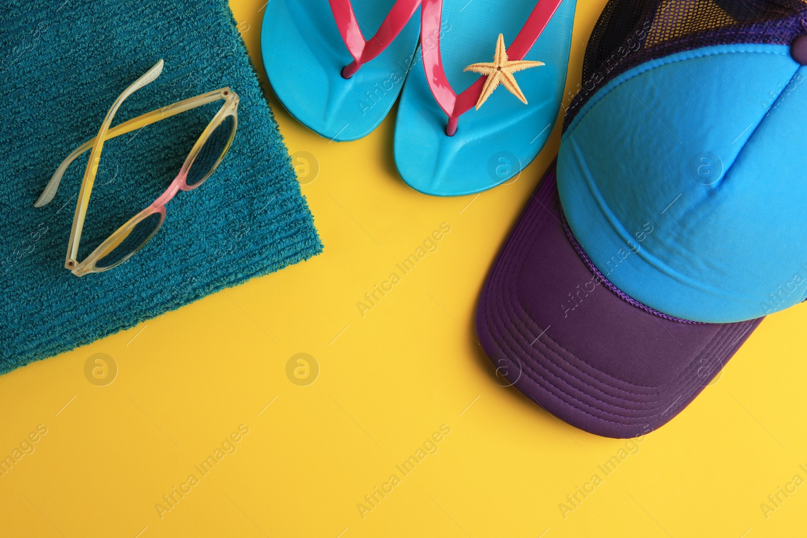 Photo of Flat lay composition with different beach accessories on yellow background. Space for text