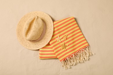 Beach towel, hat and starfishes on sand, flat lay