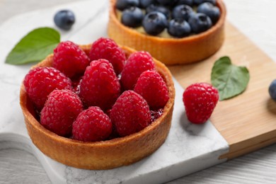 Tartlet with fresh raspberries on table, closeup. Delicious dessert