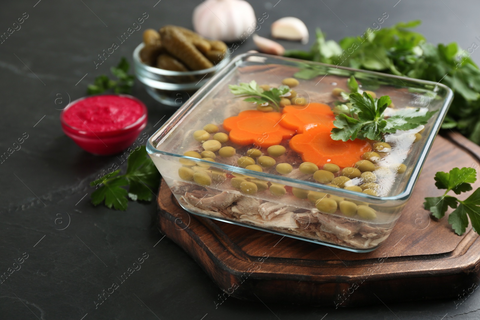 Photo of Delicious aspic with meat served on black slate table