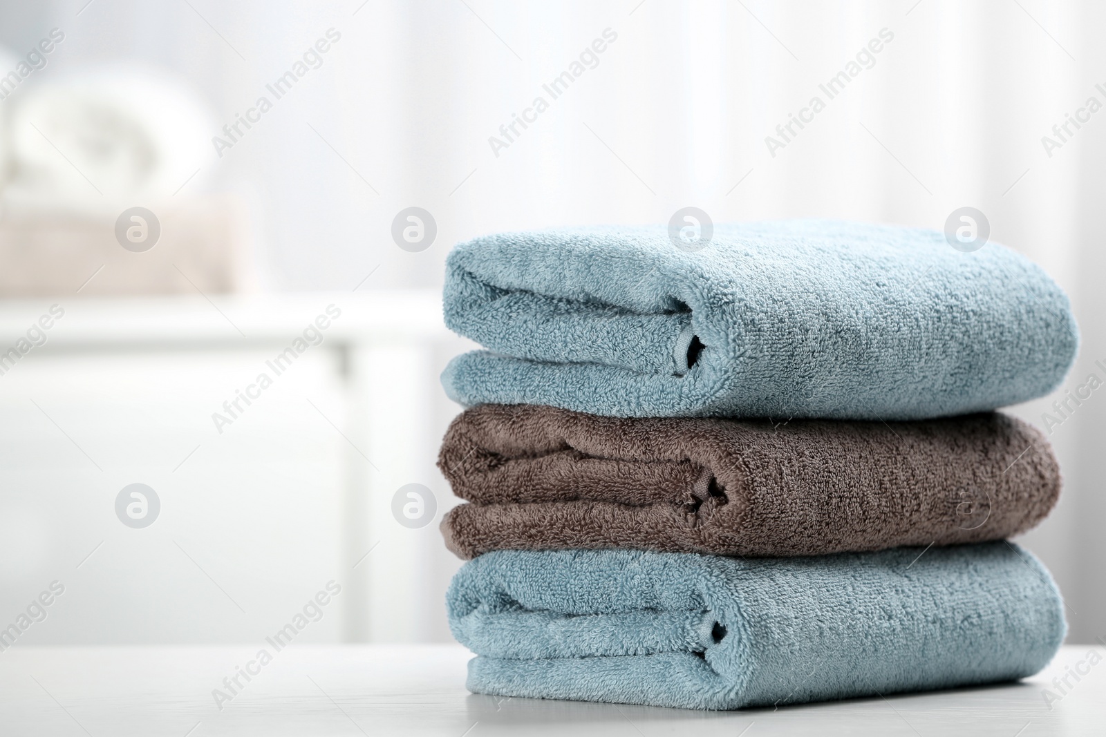 Photo of Stack of fresh towels on table. Space for text