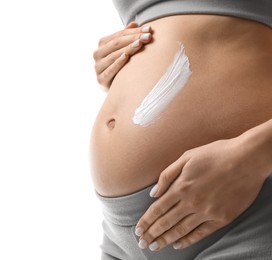 Pregnant woman applying cosmetic product on belly against white background, closeup