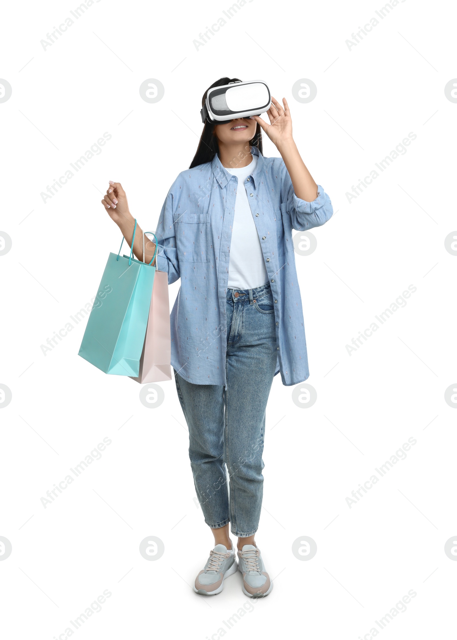 Photo of Woman with shopping bags using virtual reality headset on white background