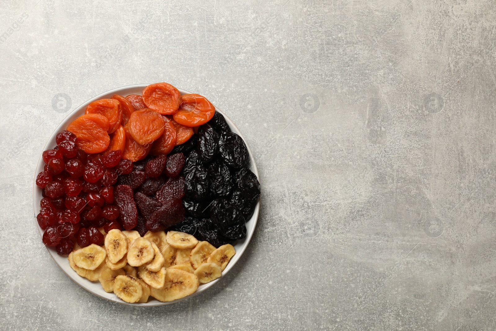 Photo of Delicious dried fruits on grey table, top view. Space for text