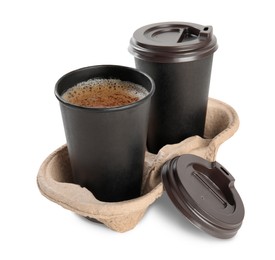 Takeaway paper cups with coffee in cardboard holder on white background