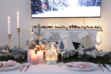 Photo of Beautiful festive place setting with Christmas decor on table indoors