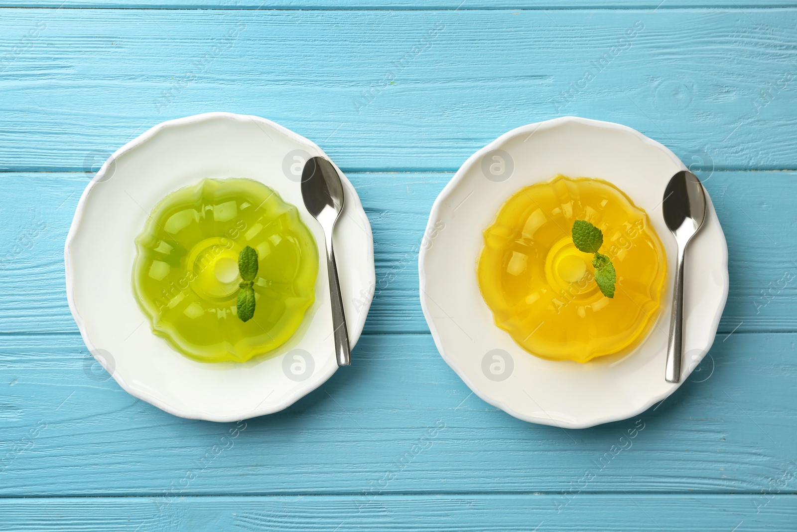 Photo of Flat lay composition with plates of fruit jelly on blue wooden table