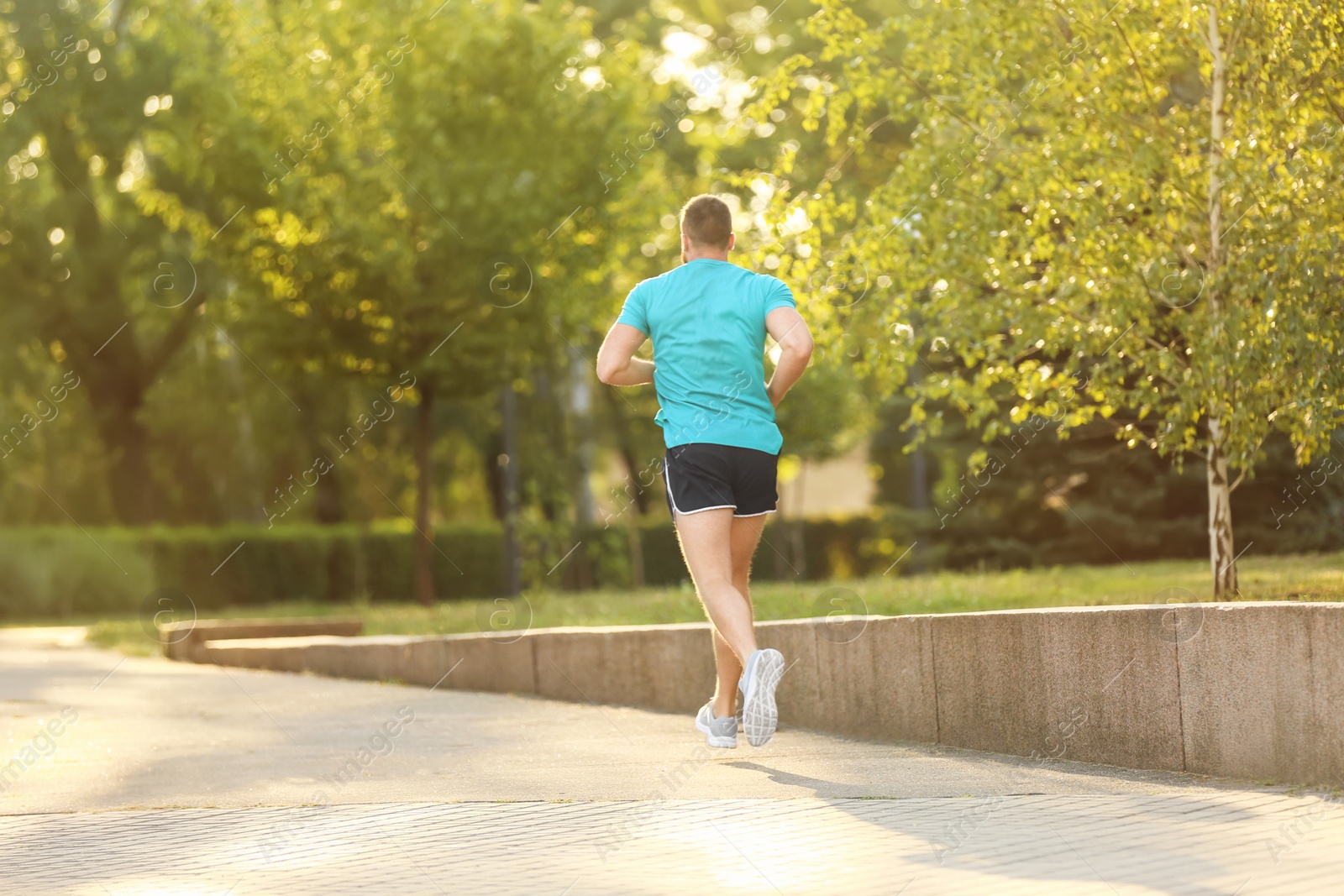 Photo of Young man running in park on sunny day