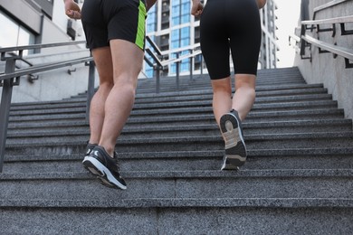 Healthy lifestyle. Couple running up steps outdoors, closeup