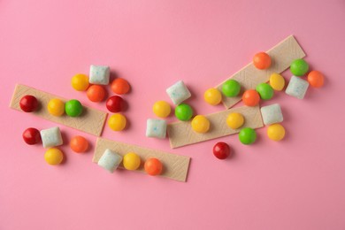 Photo of Different tasty chewing gums on pink background, flat lay