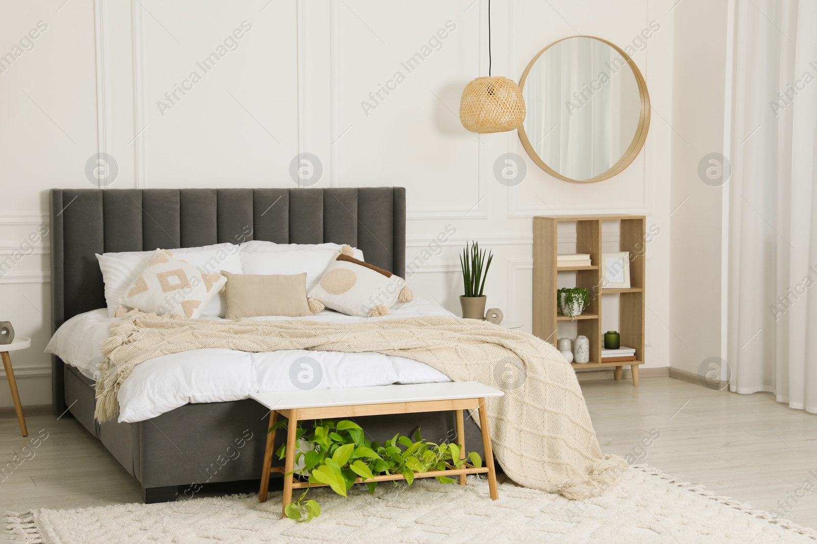 Photo of Stylish bedroom interior with large comfortable bed and mirror