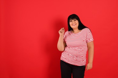 Photo of Beautiful overweight mature woman on red background. Space for text