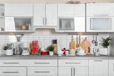 Photo of Kitchen interior with clean dishes, cookware and appliances