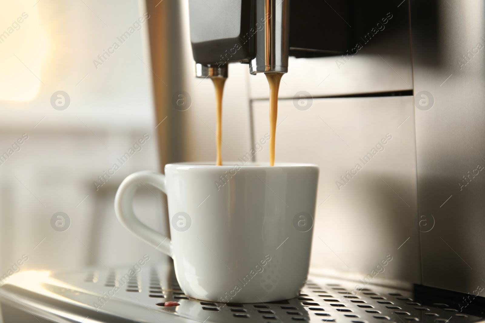 Photo of Espresso machine pouring coffee into cup against blurred background, closeup